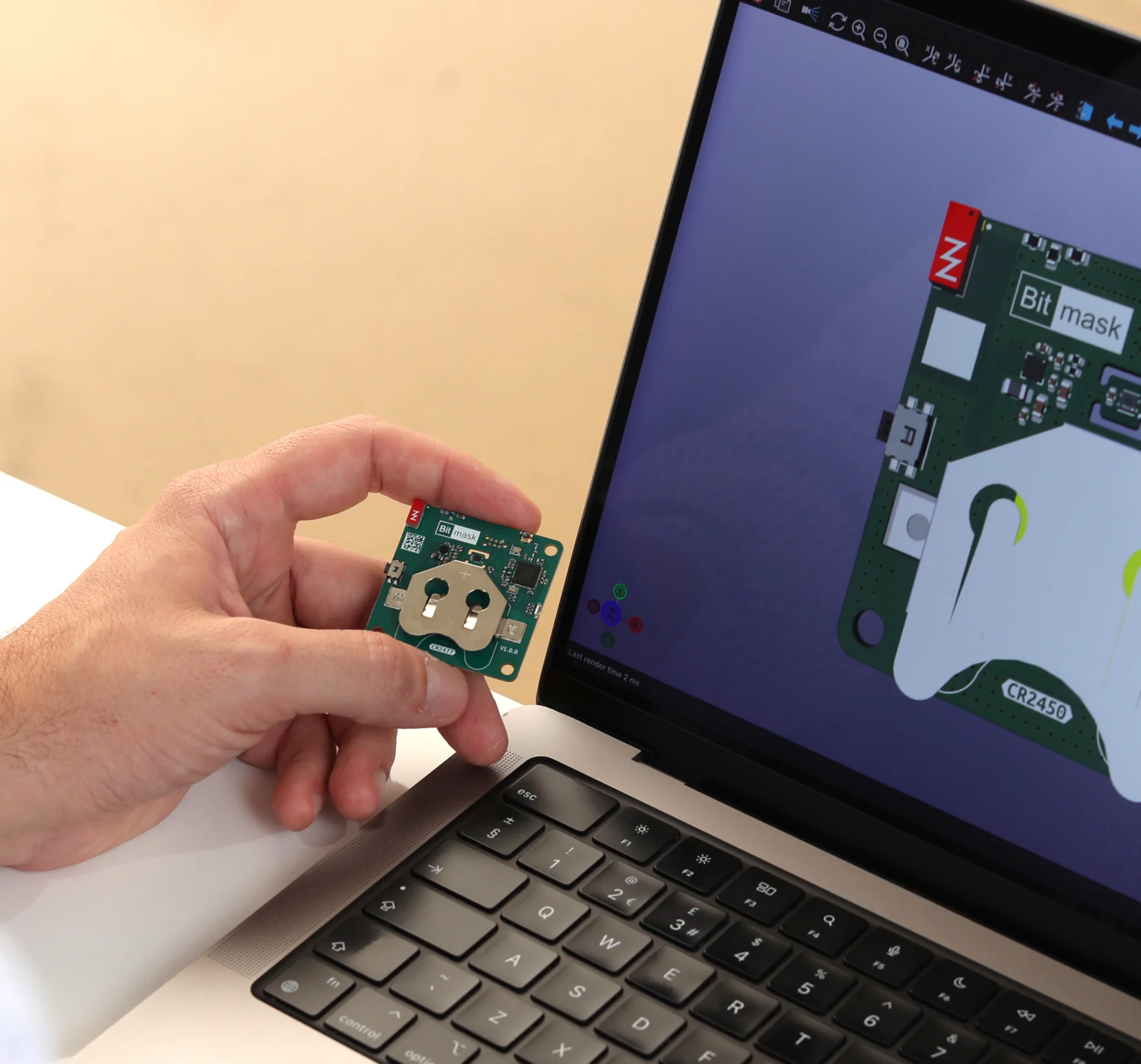 A Bitmask engineer reviewing a board's 3D layout on a laptop while holding the assembled PCB