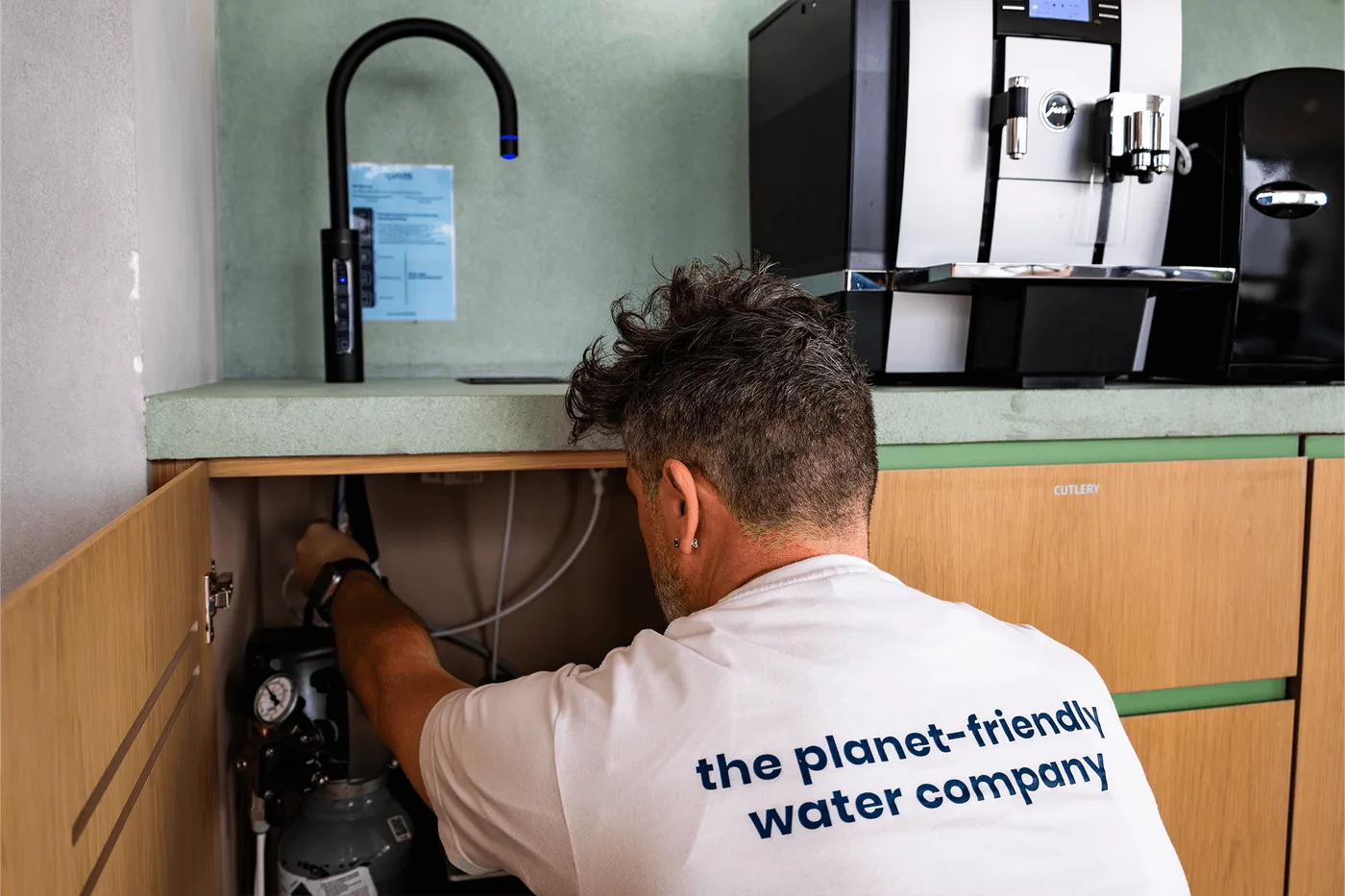 A Sprudel engineer commissioning the under-counter water system and filtration hardware on-site