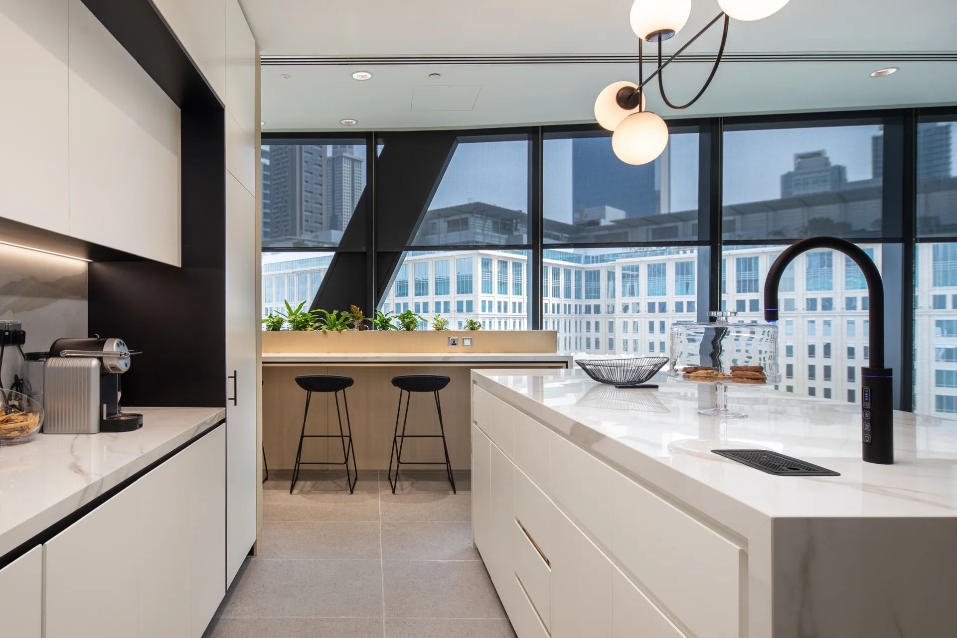 A Sprudel filtered-water tap on a marble kitchen island, overlooking a city skyline