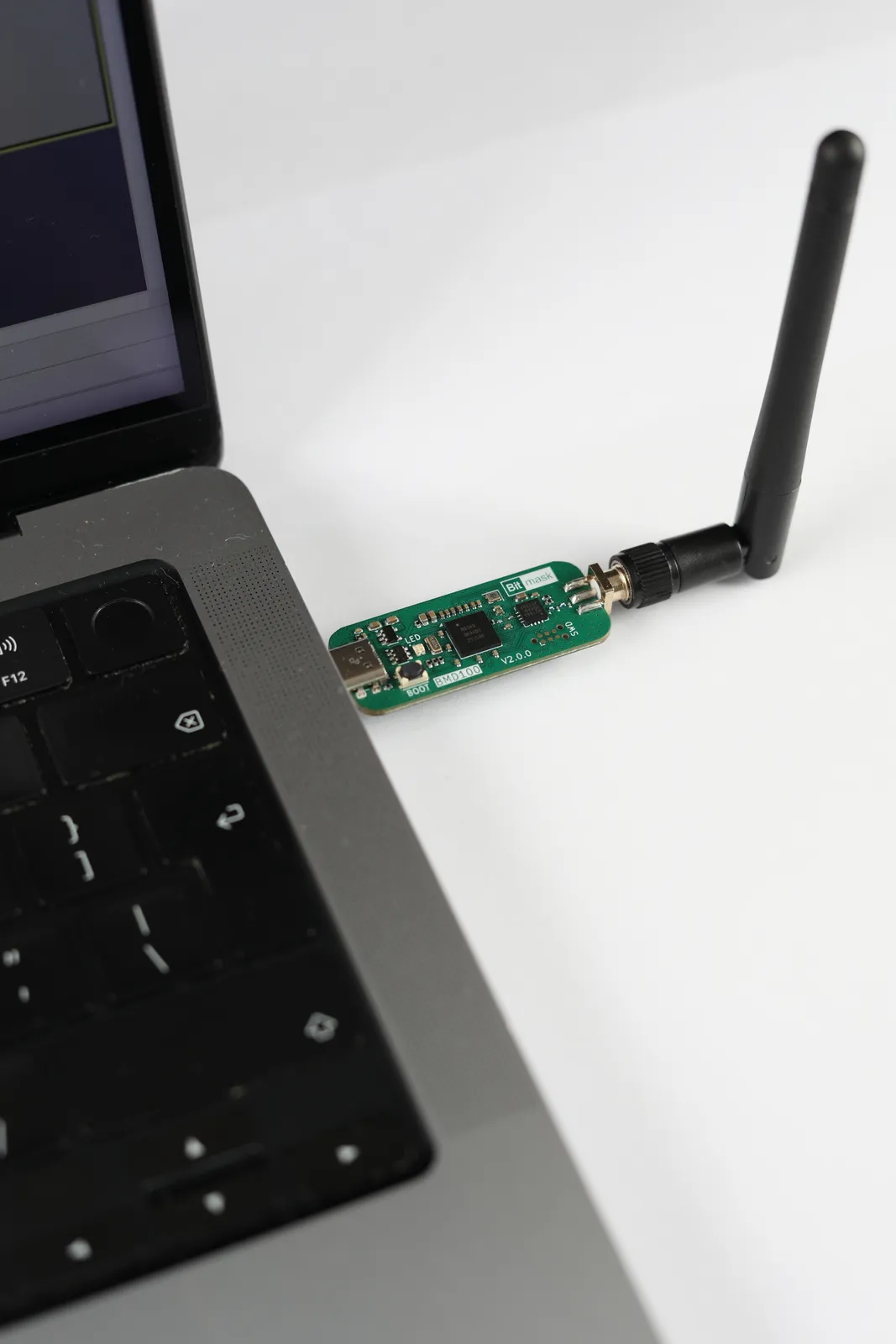 BMD100 dongle connected to a laptop USB-C port with its antenna pointing outward