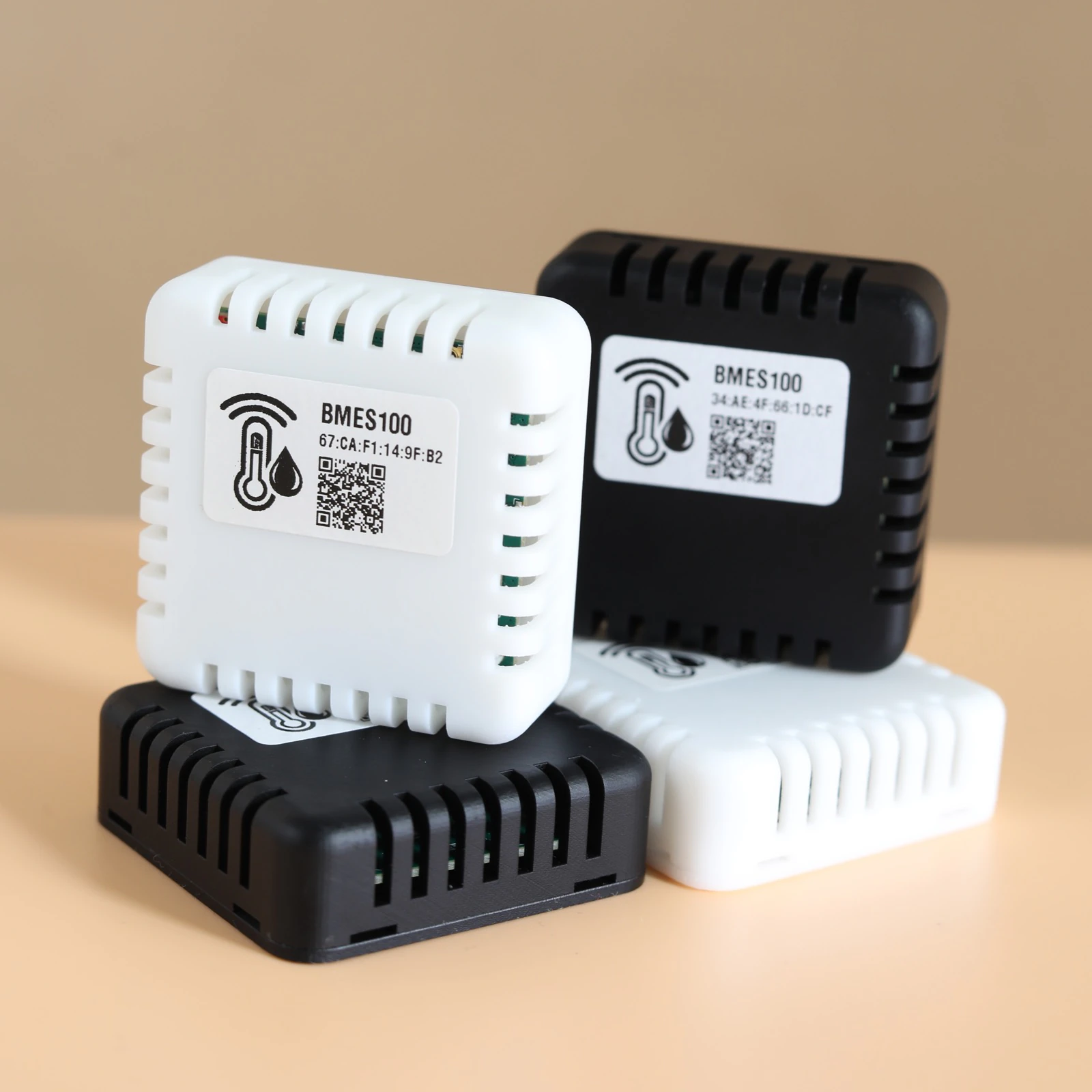 Four BMES100 sensors in white and black cases stacked together